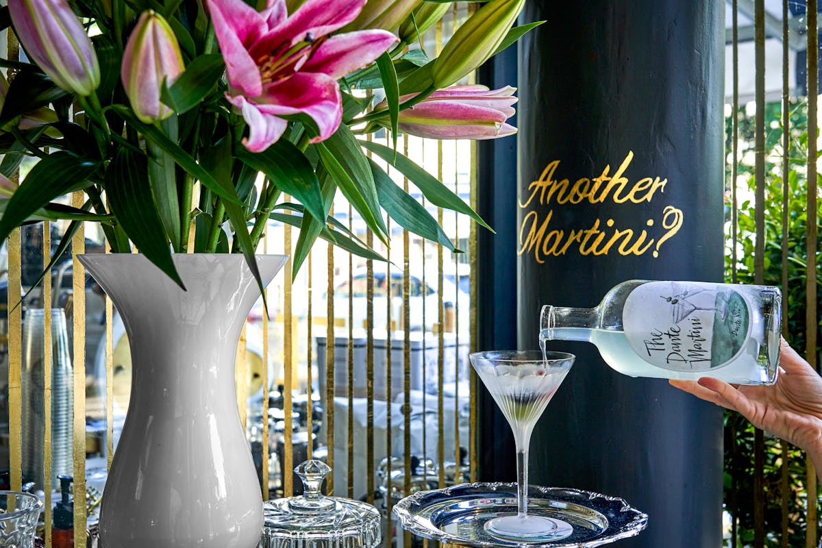 a vase of flowers on a table next to a glass of wine