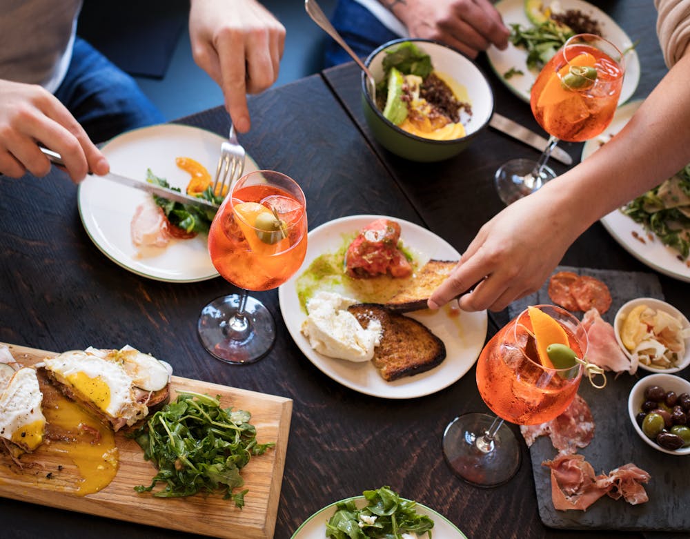 a group of people sitting at a table with a plate of food